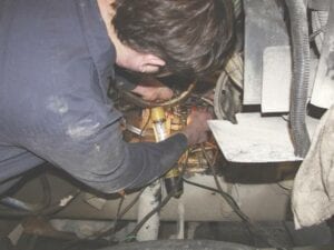 An auto mechanic working on car wires