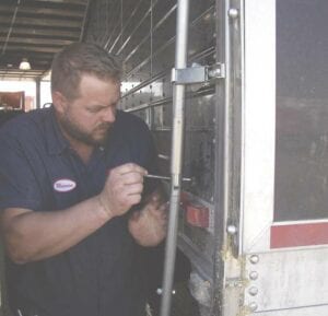 A man tightening screws on a truck